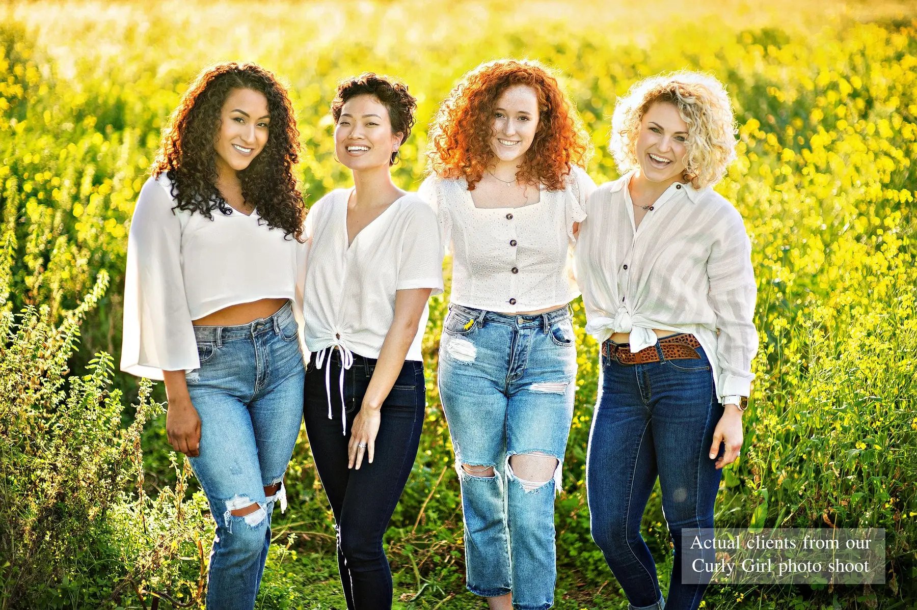 Four women with different curl types laughing in a yellow wildflower field