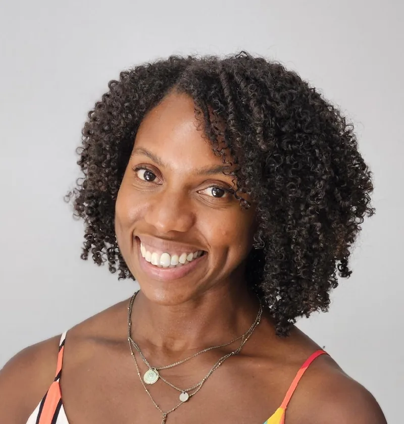 A client with full, round, defined curls after a Rëzo Cut in Lake Forest, CA